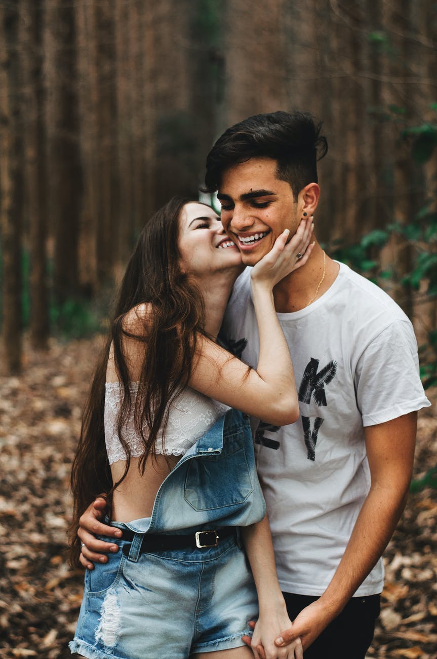 woman about to kiss the man at the forest
