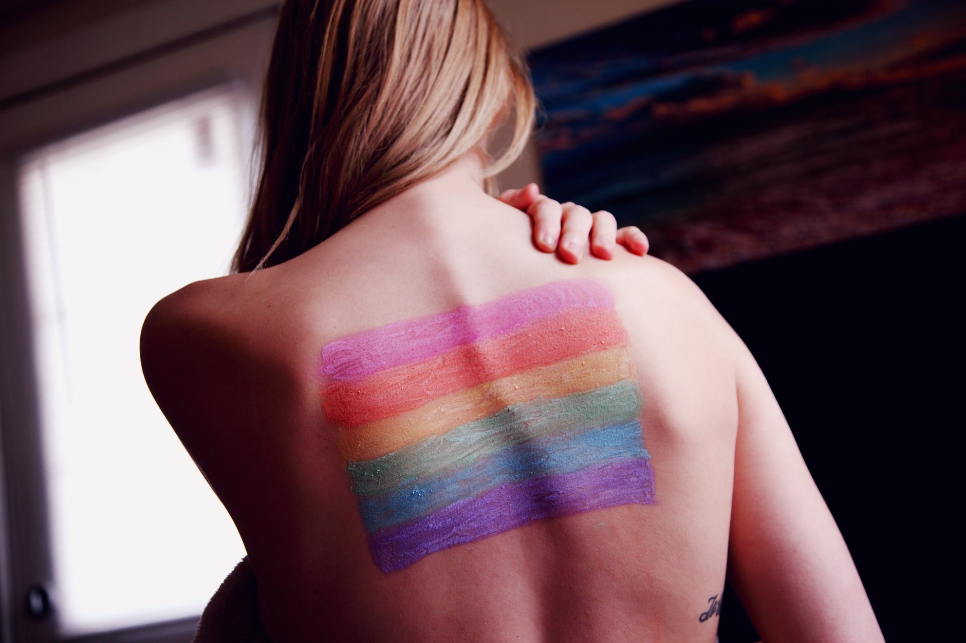 woman with a gay pride body paint on back